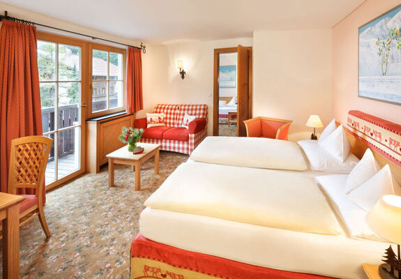 Das Doppeltbett des Hotelzimmers Schneeprinzessin, mit Blick aus dem Fenster auf die Alpen