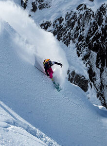 A skier descends a deep snow slope off-piste