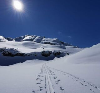 Mountain is covered in snow that glistens in the sunlight