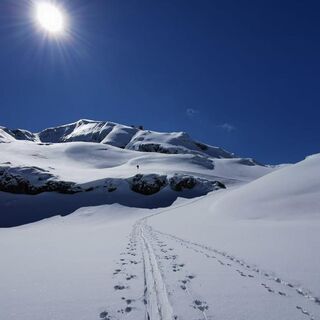 Berg ist voller Schnee bedeckt, der im Sonnenlicht klitzert