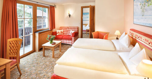 The double bed of the hotel room Snow Princess, with a view of the Alps from the window