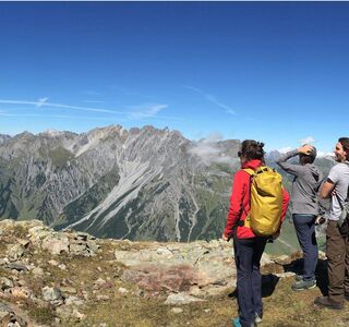 Three people marvel at the view of the mountains