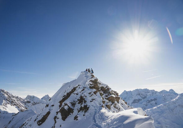 Die Berge sind mit Schnee bedeckt, die Sonne bringt diese zum Glitzern.