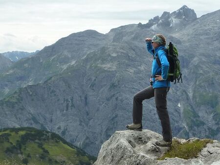 Frau steht auf Berg und schaut in die Ferne