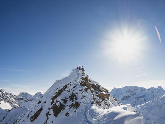 Die Berge sind mit Schnee bedeckt, die Sonne bringt diese zum Glitzern.