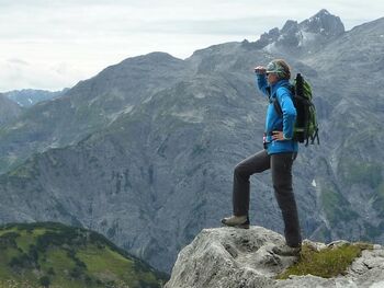 Frau steht auf Berg und schaut in die Ferne